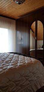 a bedroom with a large bed and a window at Apartma Sabatuš in Bohinj +4 photos