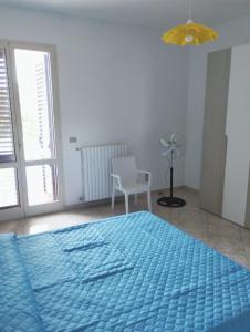 ein Schlafzimmer mit einem blauen Bett und einem Stuhl in der Unterkunft Casa Vacanze AlbaChiara in Vernole