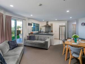 un soggiorno con un divano e un tavolo di Marinaview - Whitianga Holiday Apartment a Whitianga