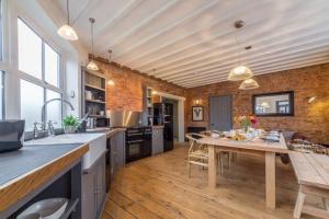 a kitchen with a wooden table and a dining room at The Old Butchers Shop 4 in Heacham