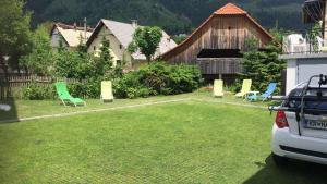 une cour avec des chaises et une voiture garée à l'intérieur dans l'établissement 18Home apartments, Mojstrana, à Mojstrana