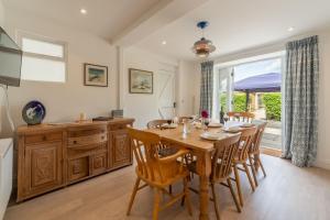 a kitchen and dining room with a wooden table and chairs at The Barn in Burnham Market