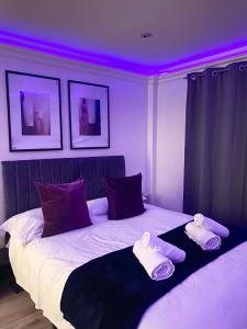 een slaapkamer met een groot bed met paarse verlichting bij Stylish En Suite double room Kensington in Londen