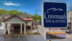 un cartello per la locanda e le suite di fronte a un edificio di Crossroads Inn & Suites a Gatlinburg