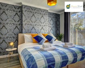 ein Schlafzimmer mit einem Bett mit einer blauen und weißen Decke in der Unterkunft 4 Bedroom House - Sleeps 7 Located Near Coventry Airport, City Centre, Free Unli Wi-fi - Driveway & Garden - AHC in Coventry