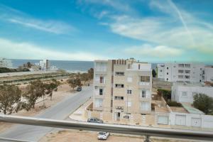 スースにあるThe Pearl Apartment Hammam Sousse WIFIの通りと海の景色を望む建物