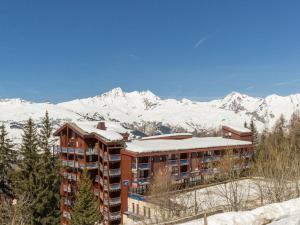 un bâtiment avec des montagnes enneigées en arrière-plan dans l'établissement Appartement Les Arcs 1800, 3 pièces, 8 personnes - FR-1-346-315, à Arc 1800