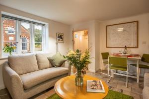 a living room with a couch and a table at Chiffchaff Cottage in West Raynham