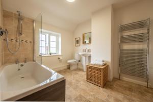 a bathroom with a tub and a shower and a toilet at Chiffchaff Cottage in West Raynham