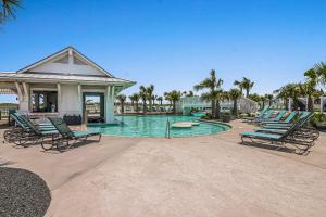 a swimming pool with lounge chairs and a house at Fairway to Heaven in Port Aransas