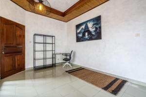 una stanza con una sedia e una foto appesa al muro di Inari Villa Nusa Dua a Nusa Dua