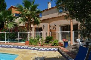 a house with a swimming pool and palm trees at Au bon vivre in Vivès