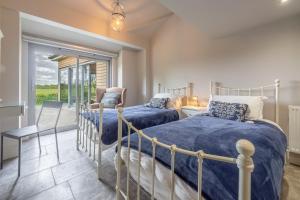 a bedroom with two beds and a balcony at Peterstone Lodge in Holkham