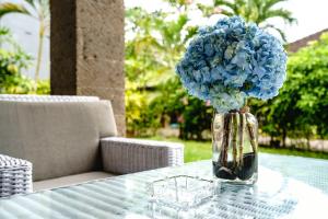 un vaso pieno di fiori blu seduto su un tavolo di Inari Villa Nusa Dua a Nusa Dua