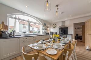 a kitchen with a wooden table with chairs and a dining room at Kipling House 8 in Wells next the Sea