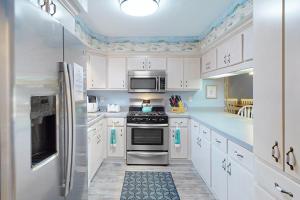 a kitchen with white cabinets and stainless steel appliances at Gulf Highlands Grande Island Blvd in Panama City Beach