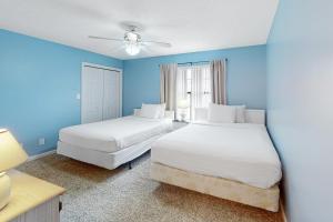 two beds in a room with blue walls at Gulf Highlands Grande Island Blvd in Panama City Beach