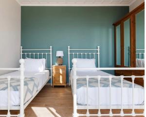 アイオス・ニコラオスにあるAlico Villa Zakynthosの青い壁のベッドルーム1室(ベッド2台付)