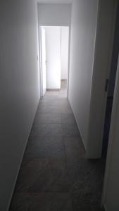 un couloir avec une porte blanche et du carrelage. dans l'établissement Orfila Apart 4, à Mendoza