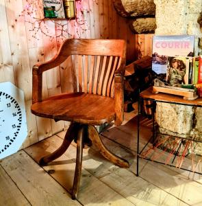 una vieja silla de madera sentada junto a una mesa en Charmante suite romantique avec cave à vin, en Cournonsec