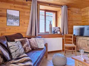 ein Wohnzimmer mit Sofa und Fernseher in der Unterkunft Chalet spacieux avec sauna, proche des Menuires et St Martin de Belleville - FR-1-344-738 in Saint-Marcel