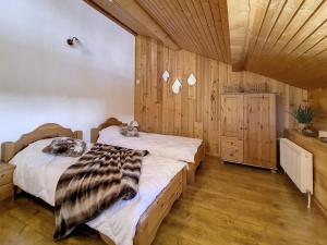 two beds in a room with wooden walls and wood floors at Chalet Saint-Martin-de-Belleville, 4 pièces, 8 personnes - FR-1-344-738 in Saint-Marcel