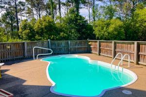 a swimming pool in a backyard with a wooden fence at Cherished Memories in Nags Head