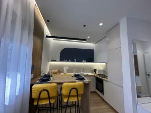 a kitchen with a table and some yellow chairs at Luxurious seaside apartment in Durrës