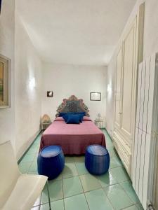 a bedroom with a bed with blue ottomans at Casa Maricla - Marea Collection in Otranto