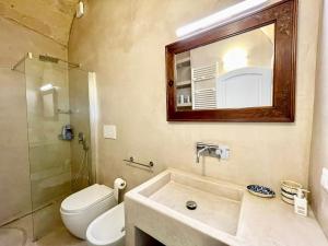 a bathroom with a sink and a toilet and a mirror at Casa Maricla - Marea Collection in Otranto