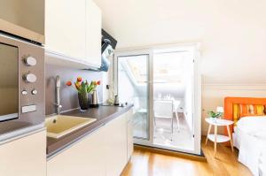 a kitchen with a sink and a counter top at Fuga romantica - Mansarda chic con box privato & mare a 150m in Loano