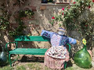 una bambola seduta accanto a una panchina verde di Agriturismo Biofattoria l'Upupa a Montalcino