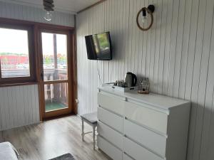 sypialnia z komodą i telewizorem na ścianie w obiekcie Cicha Zatoka w mieście Mikołajki