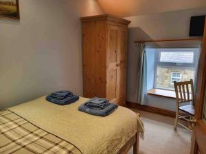 1 dormitorio con 1 cama con 2 toallas azules en Cosy cottage, Pateley Bridge, en Pateley Bridge