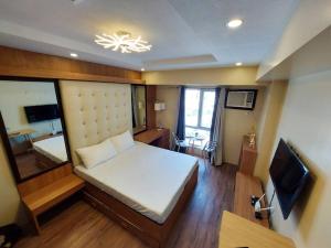 a small bedroom with a bed and a television at Centrio Tower w/ Netflix + WiFi in Cagayan de Oro