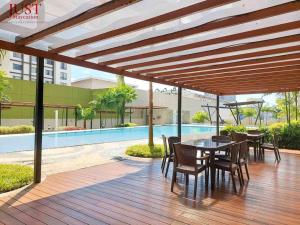 a wooden deck with a table and chairs and a pool at Centrio Tower w/ Netflix + WiFi in Cagayan de Oro +17 photos