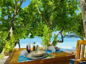 una mesa en la playa con un plato de comida en RISING SUN BEACH VIEW, en Thinadhoo