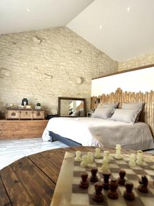 um quarto com uma cama e um tabuleiro de xadrez em L'Eden chambre d'hôtes avec jacuzzi et massages em Saint-Aubin-la-Plaine