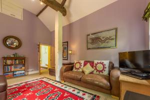 a living room with a couch and a tv at Apple Tree Barn in Langham