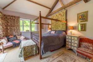 a bedroom with a canopy bed and a couch at Apple Tree Barn in Langham