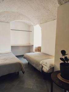 um quarto com duas camas e uma mesa em La Madriguera Eco Caves 3 em Guadix