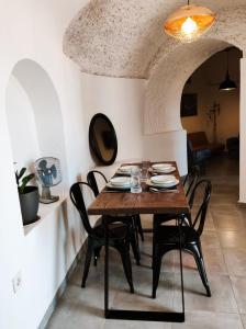 uma sala de jantar com uma mesa de madeira e cadeiras em La Madriguera Eco Caves 3 em Guadix