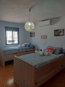 1 Schlafzimmer mit 2 Betten und einem Kronleuchter in der Unterkunft Alojamiento Rural Mi Frasca in Almodóvar del Río