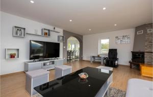 a living room with a black table and a tv at Awesome Home In Donji Prolozac With Wifi in Donji Proložac