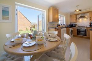 a kitchen with a wooden table with chairs and a dining room at Taureans in Wells next the Sea