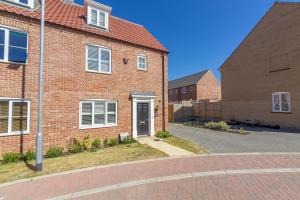 a brick house with a door in a street at Taureans in Wells next the Sea