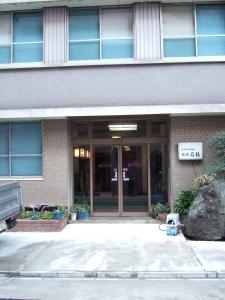 un bâtiment avec un panneau devant lui dans l'établissement Ryokan Meiryu, à Nagoya