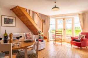 a living room with a dining table and a staircase at Gallery Cottage in Wighton