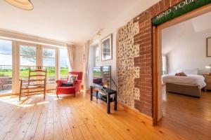 a living room with a brick wall and a fireplace at Gallery Cottage in Wighton