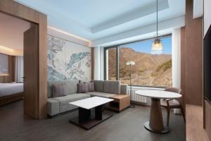 张家口崇礼万怡酒店的酒店客房设有沙发和大窗户